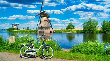 Blick auf Windmühlen, Fluss und Fahrrad.