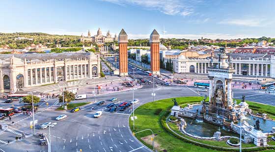 Straße in Barcelona mit Brunnen und alten Gebäuden.