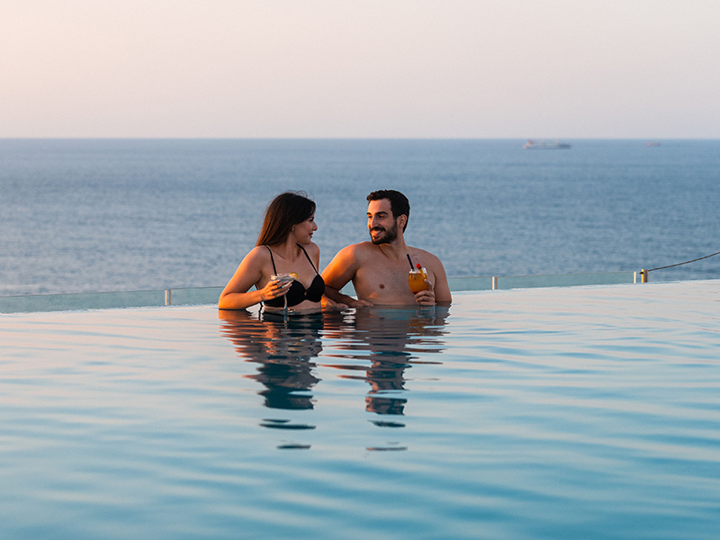 Paar sitzt im Infinity Pool.