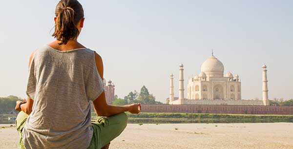 Frau sitzt vor dem Taj Mahal