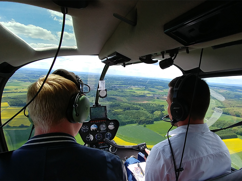 Zwei Männer im Cockpit eines Hubschraubers.