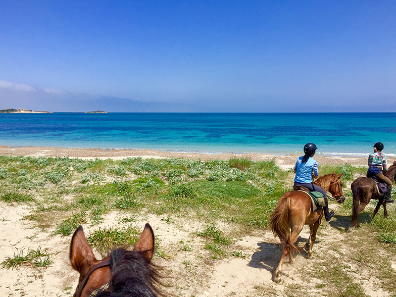 Strand von Sardinien am Hotel mit Reitern.