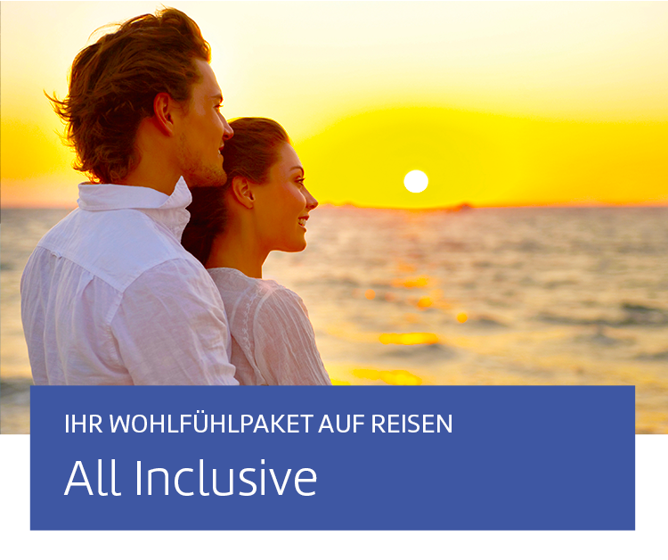 Ein Paar, welches auf das Meer während eines Sonnenuntergangs schaut.