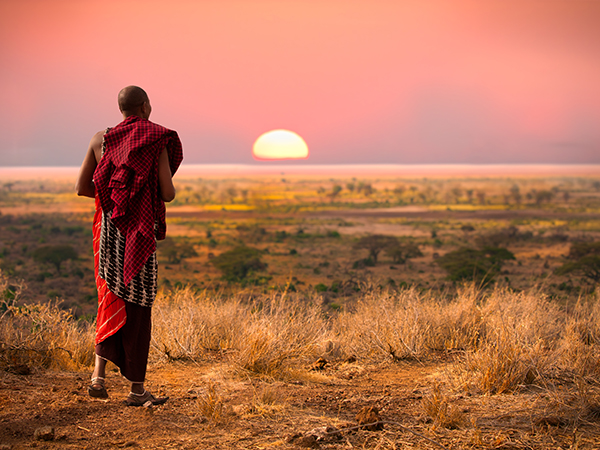 Massai läuft im Sonnenuntergang.