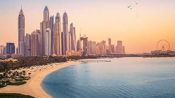 Blick auf die Skyline von Dubai und einen Strand.