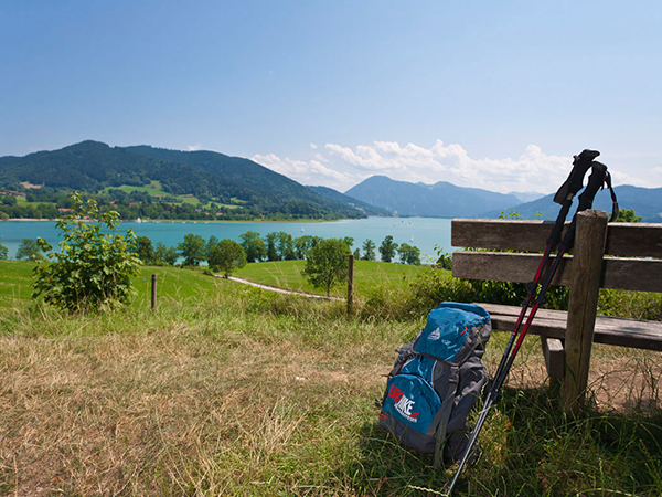 Ausblick von einer Bank auf einen See und Berge Bayerns.