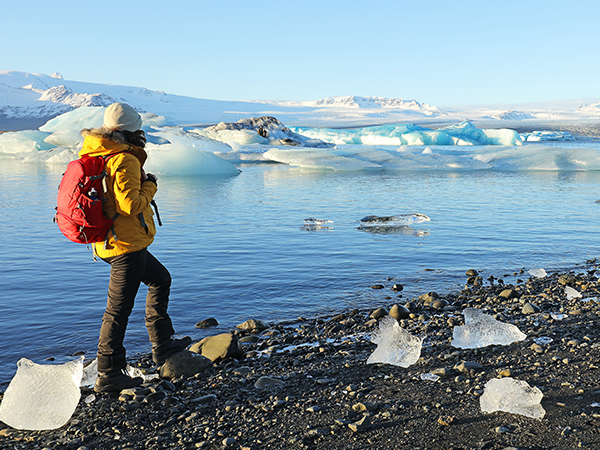 Frau steht vor der Gletscherlagune Jökulsárlón.