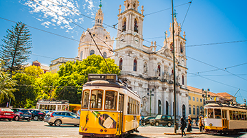 Straße in Lissabon mit Kirche und Straßenbahn.