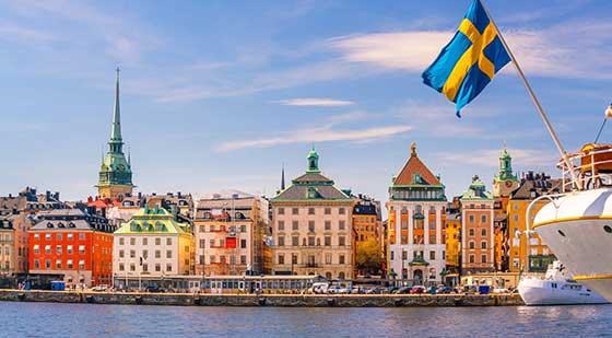 Häuser in Stockholm und Boot mit Schweden-Flagge.